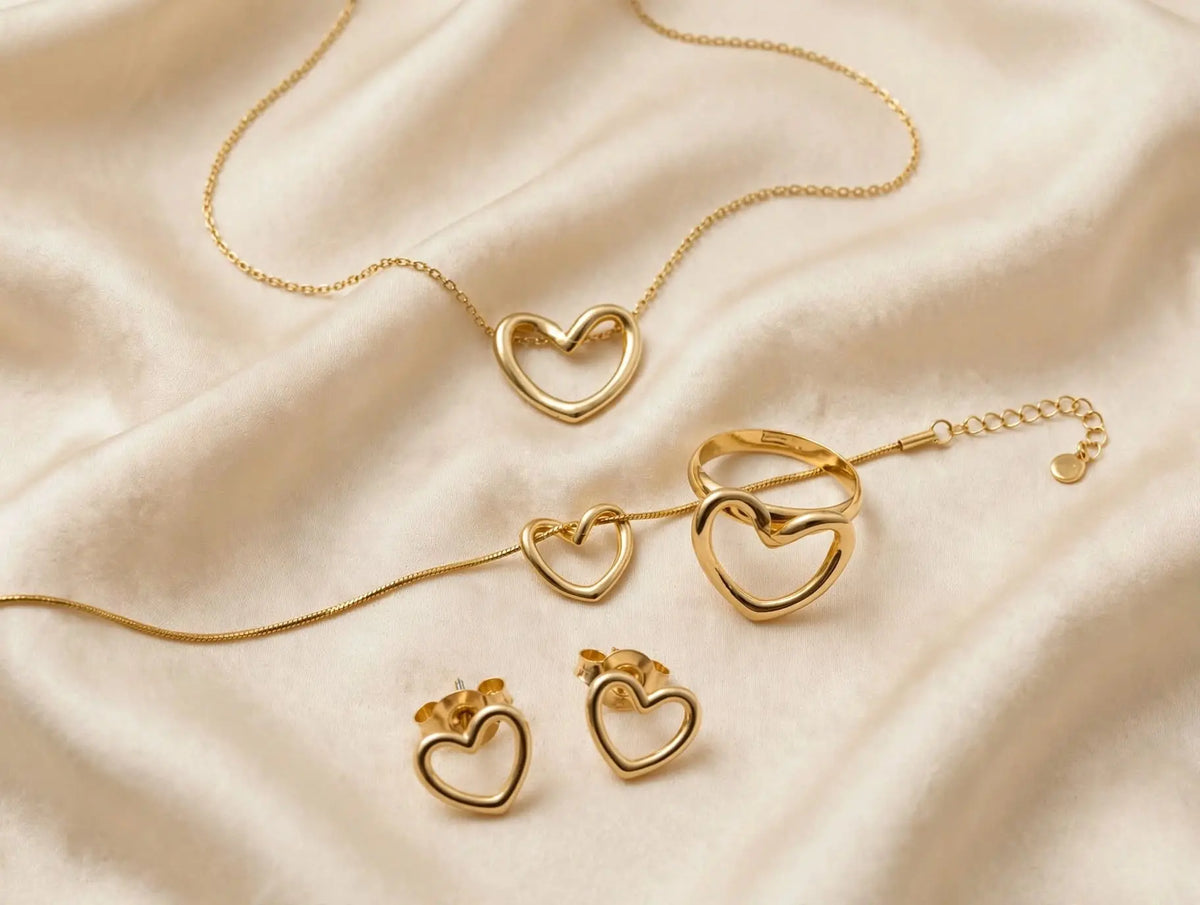 LUVORA Golden Heart 4 Pcs Set - gold heart necklace ring earrings bracelet on beige silk flat lay