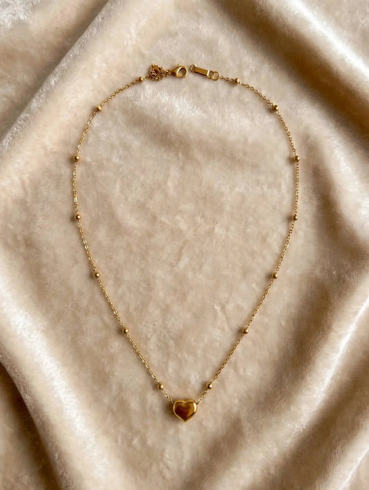 LUVORA gold heart beaded necklace on beige velvet